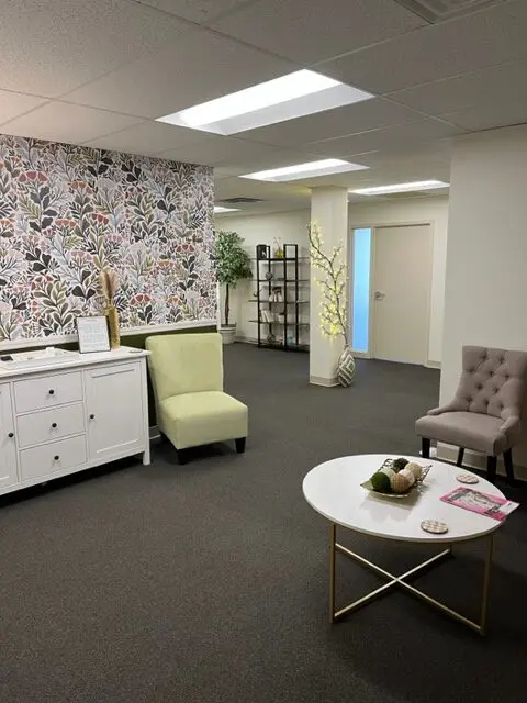 Office with vibrant wallpaper and comfortable seating.